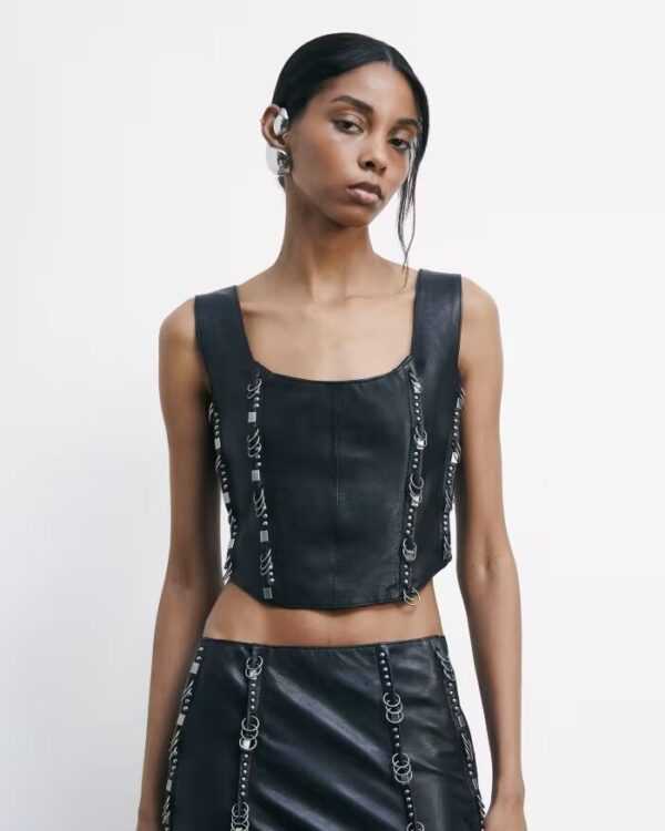 Top de piel con tachuelas y piercings
