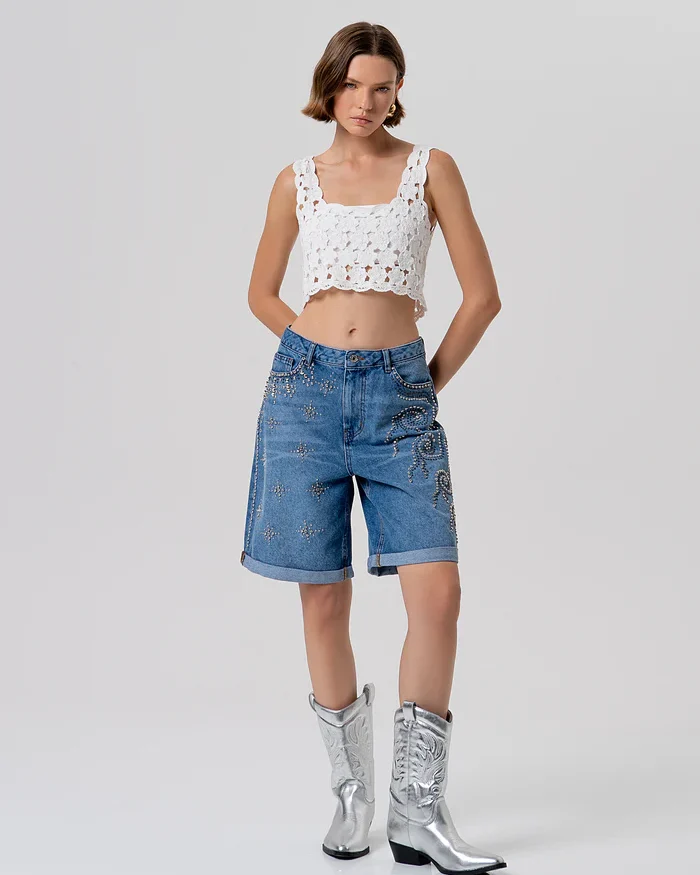 Bermuda acampanada en denim con lavado medio y aplicaciones brillantes